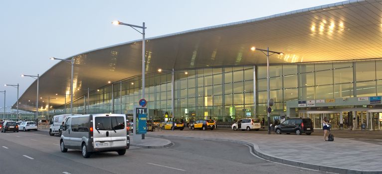 BARCELONA, SPAIN - JULY 16, 2015: Terminal T1 of El Prat-Barcelona airport. This airport was inaugurated in 1963. Airport is one of the biggest in Europe.

Barcelona, Spain - July 16, 2015: Terminal T1 of El Prat-Barcelona airport. This airport was inaugurated in 1963. Airport is one of the biggest in Europe and one of the busiest in the world. People are standing outside.