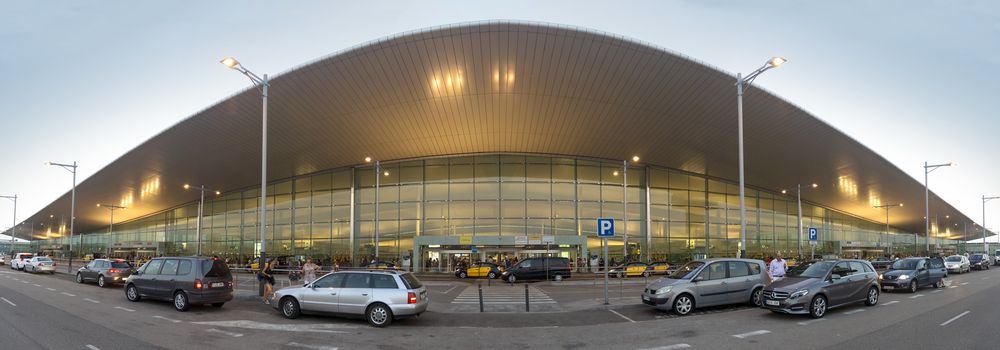 BARCELONA, SPAIN - JULY 16, 2015: Terminal T1 of El Prat-Barcelona airport. This airport was inaugurated in 1963. Airport is one of the biggest in Europe.

Barcelona, Spain - July 16, 2015: Terminal T1 of El Prat-Barcelona airport. This airport was inaugurated in 1963. Airport is one of the biggest in Europe and one of the busiest in the world. People are standing outside.