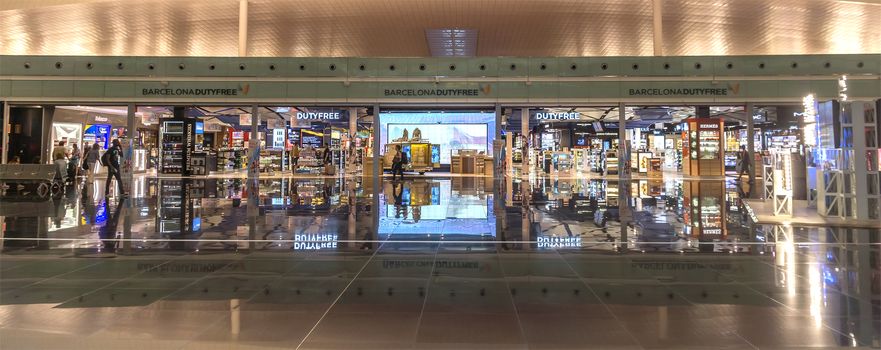 BARCELONA, SPAIN - JULY 16, 2015: Duty free shop inside modern El Prat airport of Barcelona. El Prat airport is second biggest in Spain with year traffic about 30mln. passengers. Airport was inaugurated in 1963.

Barcelona, Spain - July 16, 2015: Duty free shop inside modern El Prat airport of Barcelona. El Prat airport is second biggest in Spain with year traffic about 30mln. passengers. Airport was inaugurated in 1963.