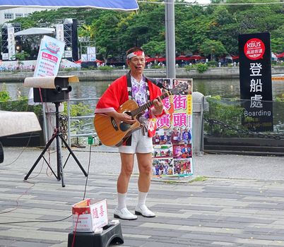 KAOHSIUNG, TAIWAN -- JUNE 9, 2016: A male busker wearing Japanese clothes performs popular Japanese songs on the banks of the Love River.