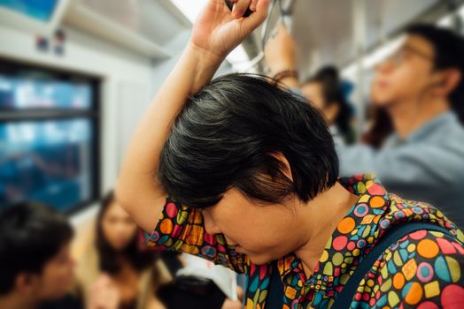 Asian woman travel on skytrain train in city. Many people in city used skytrain to save time.