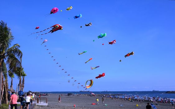 KAOHSIUNG, TAIWAN -- AUGUST 13 , 2017: Colorful kites are flying high as part of the yearly Black Sand Beach Festival on Cijin Island.