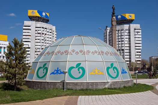 ALMATY, KAZAKHSTAN - APRIL 17, 2015: Buildings on the Republic Square. Almaty is the largest city in Kazakhstan, and was the country's capital until 1997.

Almaty, Kazakhstan - April 17, 2015: Buildings on the Republic Square. Almaty is the largest city in Kazakhstan, and was the country's capital until 1997. People sit on the bench.