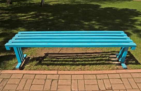 Wooden blue bench in the city park.