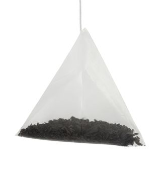 Tea bag for brewing in a cup isolated over white. Clipping path included.