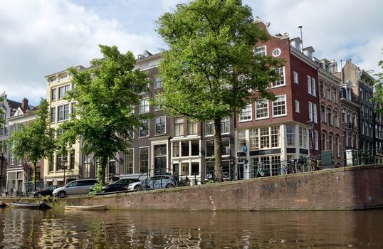 AMSTERDAM, NETHERLANDS - MAY 30: Amsterdam canals on May 30, 2014 in Amsterdam, Netherlands. View of Amsterdam canals and typical dutch houses.

Amsterdam, Netherlands - May 30, 2014: View of Amsterdam canals and typical dutch houses.