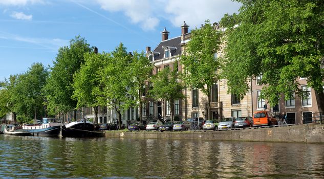 AMSTERDAM, NETHERLANDS - MAY 30: Amsterdam canals on May 30, 2014 in Amsterdam, Netherlands. View of Amsterdam canals and typical dutch houses.

Amsterdam, Netherlands - May 30, 2014: View of Amsterdam canals and typical dutch houses.