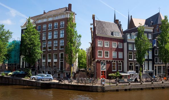 AMSTERDAM, NETHERLANDS - MAY 30: Amsterdam canals on May 30, 2014 in Amsterdam, Netherlands. View of Amsterdam canals and typical dutch houses.

Amsterdam, Netherlands - May 30, 2014: View of Amsterdam canals and typical dutch houses. People are resting on the street.