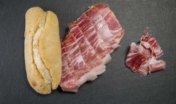 Iberian acorn ham sandwich with its knife, tomato and garlic. Spanish typical tapas