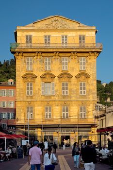 NICE, FRANCE - MAY 31, 2014: Old building and a cafe in the Cours Saleya. The Cours Saleya is a place of outdoor restaurants, boutiques and a market.

Nice, France - May 31, 2014: Old building and a cafe in the Cours Saleya. The Cours Saleya is a place of outdoor restaurants, boutiques and a market. People are walking and relaxing.