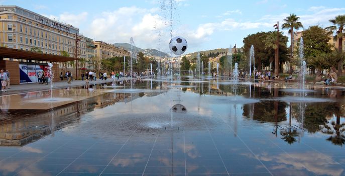 NICE, FRANCE - MAY 31, 2014: Lovely fountain on Place Massena in Nice. Place Massena is Main Square of the city and it is used for concerts and other events which take place in the city. 

Nice, France - May 31, 2014: Lovely fountain on Place Massena in Nice. Place Massena is Main Square of the city and it is used for concerts and other events which take place in the city. People are walking near fountain.