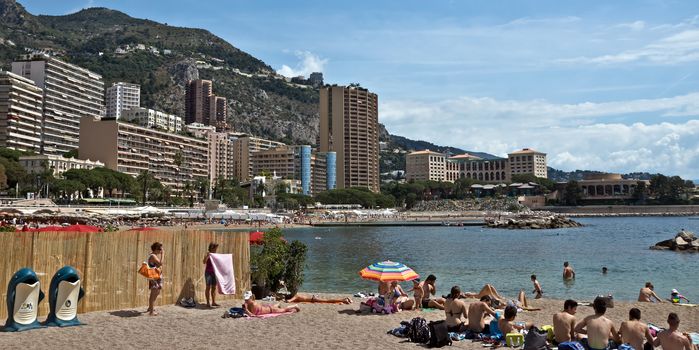 MONTE CARLO, MONACO - JUNE 1, 2014: Architecture of residential buildings from the city beach.

Monte Carlo, Monaco - June 1, 2014: Architecture of residential buildings from the city beach. People are taking a sunbath, sunbathing and swiming.