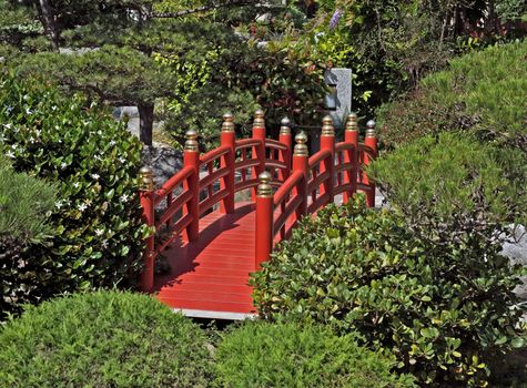 Red bridge over a pond in Japanese garden in Monte Carlo, Monaco.