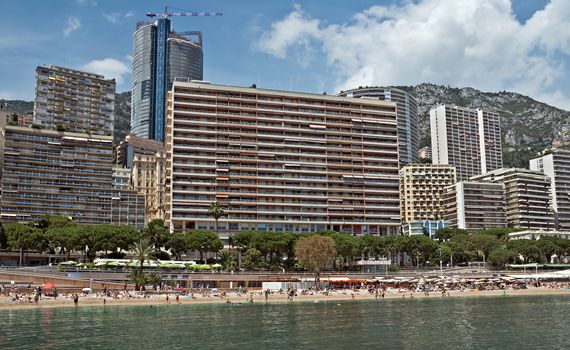 MONTE CARLO, MONACO - JUNE 1, 2014: Architecture of residential buildings from the city beach.

Monte Carlo, Monaco - June 1, 2014: Architecture of residential buildings from the city beach. People are taking a sunbath, sunbathing and swiming.