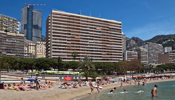 MONTE CARLO, MONACO - JUNE 1, 2014: Architecture of residential buildings from the city beach.

Monte Carlo, Monaco - June 1, 2014: Architecture of residential buildings from the city beach. People are taking a sunbath, sunbathing and swiming.