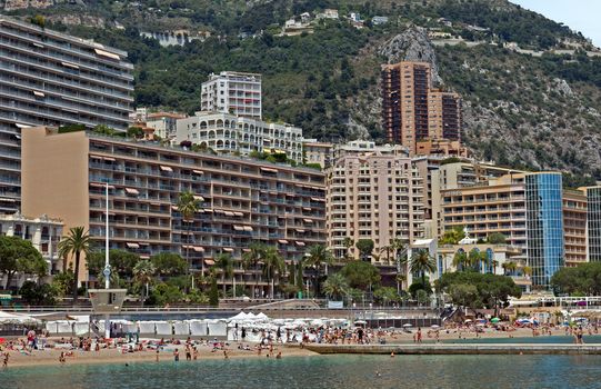 MONTE CARLO, MONACO - JUNE 1, 2014: Architecture of residential buildings from the city beach.

Monte Carlo, Monaco - June 1, 2014: Architecture of residential buildings from the city beach. People are taking a sunbath, sunbathing and swiming.