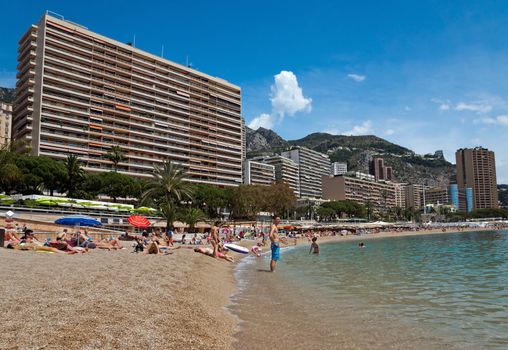 MONTE CARLO, MONACO - JUNE 1, 2014: Architecture of residential buildings from the city beach.

Monte Carlo, Monaco - June 1, 2014: Architecture of residential buildings from the city beach. People are taking a sunbath, sunbathing and swiming.