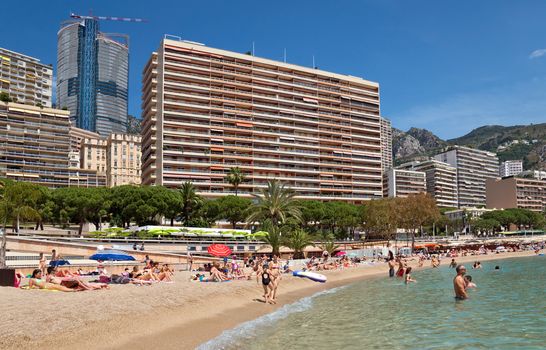 MONTE CARLO, MONACO - JUNE 1, 2014: Architecture of residential buildings from the city beach.

Monte Carlo, Monaco - June 1, 2014: Architecture of residential buildings from the city beach. People are taking a sunbath, sunbathing and swiming.