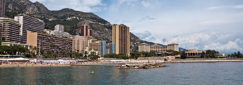 MONTE CARLO, MONACO - JUNE 1, 2014: Architecture of residential buildings from the city beach.

Monte Carlo, Monaco - June 1, 2014: Architecture of residential buildings from the city beach. People are taking a sunbath, sunbathing and swiming.
