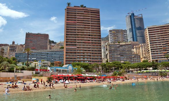 MONTE CARLO, MONACO - JUNE 1, 2014: Architecture of residential buildings from the city beach.

Monte Carlo, Monaco - June 1, 2014: Architecture of residential buildings from the city beach. People are taking a sunbath, sunbathing and swiming.