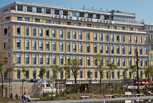 NICE, FRANCE - JUNE 3, 2014: View on the Grand Hotel Aston. Hotel is founded in the early 1930s.

Nice, France - June 3, 2014: View on the Grand Hotel Aston. Hotel is founded in the early 1930s. People are resting on the benches.