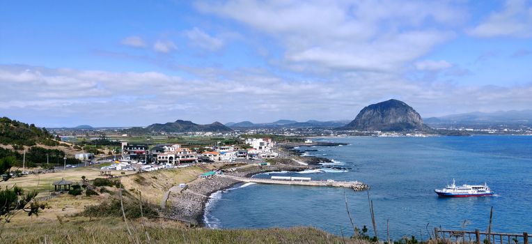 A landscape view of blue sea and Sanbang-san mountain seen from songaksan mountain in Jeju Island, South Korea