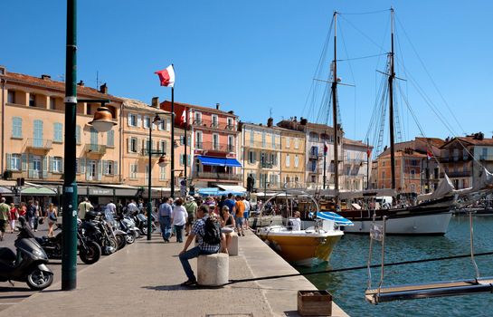 SAINT TROPEZ, FRANCE - JUNE 5, 2014: Architecture of Saint Tropez city in the port. French Riviera, France. 

Saint Tropez, France - June 5, 2014: Architecture of Saint Tropez city in the port. French Riviera, France. People are walking and are resting by street.