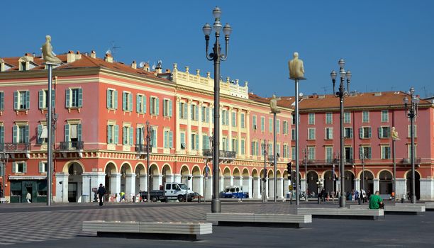 NICE, FRANCE - JUNE 3, 2014: Views of the Place Massena. Square is located in the city center and is the most popular destination among tourists. There are many boutiques, cafes and restaurants.

Nice, France - June 3, 2014: Views of the Place Massena. Square is located in the city center and is the most popular destination among tourists. There are many boutiques, cafes and restaurants. People are walking thru scuare.