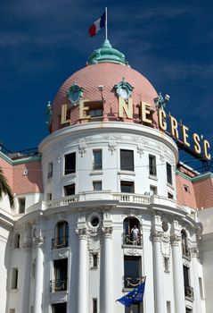 NICE, FRANCE - JUNE 6, 2014: Luxury Hotel Negresco on English Promenade in Nice, French Riviera. Hotel Negresco is the famous luxury hotel on the Promenade des Anglais in Nice.

Nice, France - June 6, 2014: Luxury Hotel Negresco on English Promenade in Nice, French Riviera. Hotel Negresco is the famous luxury hotel on the Promenade des Anglais in Nice, a symbol of the Cote d'Azur. Man is standing on the balcony.