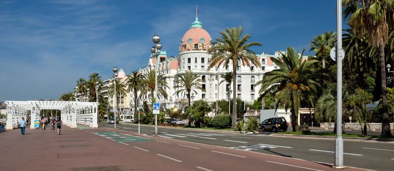 NICE, FRANCE - JUNE 6, 2014: Luxury Hotel Negresco on English Promenade in Nice, French Riviera. Hotel Negresco is the famous luxury hotel on the Promenade des Anglais in Nice, a symbol of the Cote d'Azur.

Nice, France - June 6, 2014: Luxury Hotel Negresco on English Promenade in Nice, French Riviera. Hotel Negresco is the famous luxury hotel on the Promenade des Anglais in Nice, a symbol of the Cote d'Azur. People are walking by Promenade.