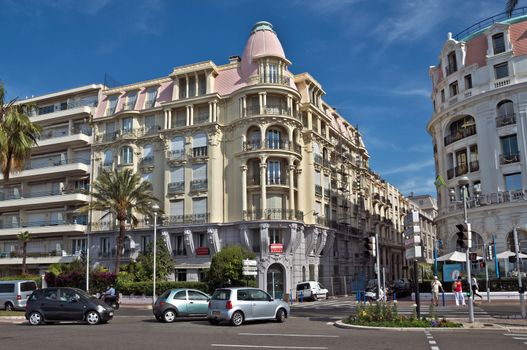 NICE, FRANCE - JUNE 6, 2014: Architecture along Promenade des Anglais. Promenade des Anglais is a symbol of the Cote d'Azur and was built in 1830 at the expense of the British colony.

Nice, France - June 6, 2014: Architecture along Promenade des Anglais. Promenade des Anglais is a symbol of the Cote d'Azur and was built in 1830 at the expense of the British colony. People are walking by street.