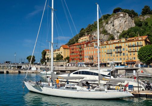 NICE, FRANCE - JUNE 5, 2014: White yachts in the Port de Nice in French Riviera. Port de Nice was started in 1745.

Nice, France - June 5, 2014: White yachts in the Port de Nice in French Riviera. Port de Nice was started in 1745. People are standing on the deck of a yacht.