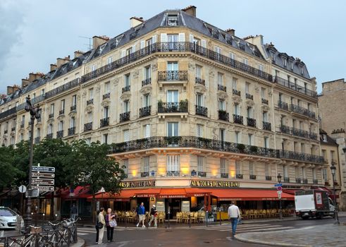 PARIS, FRANCE - JUNE 9, 2014: View of the typical french architecture.

Paris, France - June 9, 2014: View of the typical french architecture. People are walking by street.