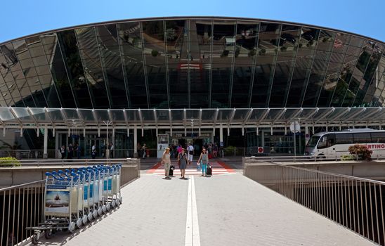 NICE, FRANCE - JUNE 8: Terminal building at Nice Cote d'Azur Airport on June 8, 2014 in Nice, France. It is the third busiest airport in France.

Nice, France - June 8, 2014: Terminal building at Nice Cote d'Azur Airport. It is the third busiest airport in France. People come out of the airport.