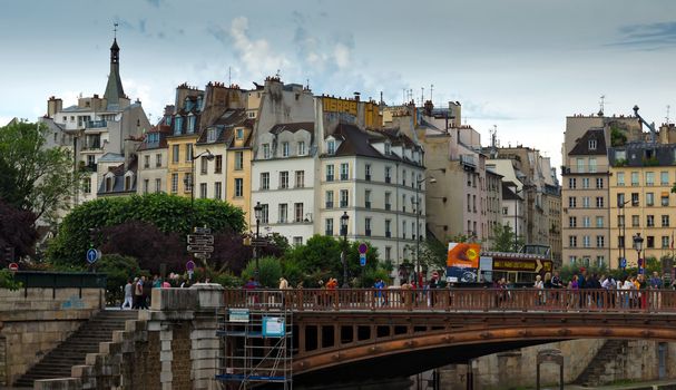 PARIS, FRANCE - JUNE 9, 2014: View of the typical french architecture.

Paris, France - June 9, 2014: View of the typical french architecture. People are walking by bridge.