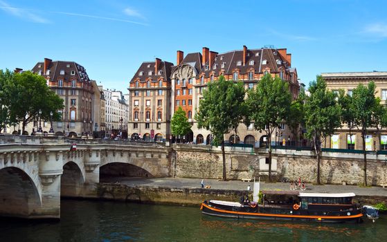PARIS, FRANCE - JUNE 9, 2014: View of the Seine River and landmarks of Paris.

Paris, France - June 9, 2014: View of the Seine River and landmarks of Paris. People are walking near river.