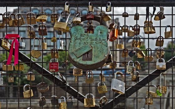 PARIS, FRANCE - JUNE 9, 2014: Love Padlocks at Pont des Arts over the river Seine. The thousands of locks of loving couples symbolize love forever. It is the narrowest road bridge in Paris and it was built in 1828.

Paris, France - June 9, 2014: Love Padlocks at Pont des Arts over the river Seine. The thousands of locks of loving couples symbolize love forever. It is the narrowest road bridge in Paris and it was built in 1828.