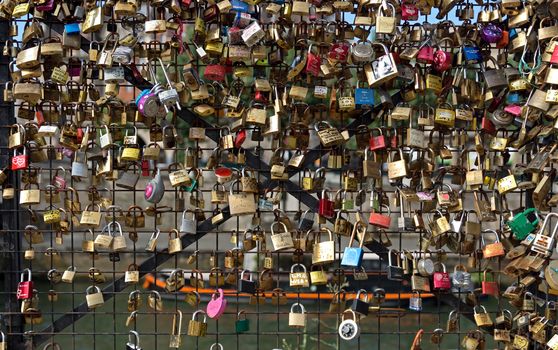 PARIS - JUNE 9: Love Padlocks at Pont des Arts on June 9, 2014, in Paris, France. The thousands of locks of loving couples symbolize love forever. 

Paris, France - June 9, 2014: Love Padlocks at Pont des Arts over the river Seine. The thousands of locks of loving couples symbolize love forever. It is the narrowest road bridge in Paris and it was built in 1828