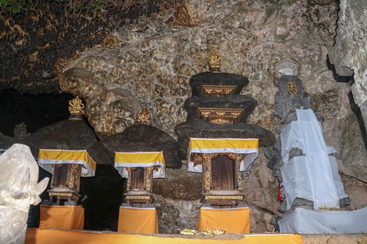 Altars at Pura Goa Lawah or Bat Cave Temple. Balinese Hindu temple in Pesinggahan, Klungkung, Bali, Indonesia. Many bats hanging from the ceiling of the Cave of bats. Colony of bats are waiting dark.