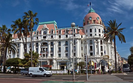 NICE, FRANCE - JUNE 6, 2014: Luxury Hotel Negresco on English Promenade in Nice, French Riviera. Hotel Negresco is the famous luxury hotel on the Promenade des Anglais in Nice, a symbol of the Cote d'Azur.

Nice, France - June 6, 2014: Luxury Hotel Negresco on English Promenade in Nice, French Riviera. Hotel Negresco is the famous luxury hotel on the Promenade des Anglais in Nice, a symbol of the Cote d'Azur. People are walking by street.