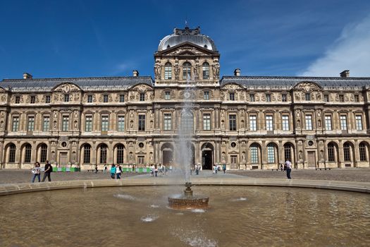 PARIS, FRANCE - JUNE 9, 2014: The Louvre Museum. Louvre is one of the biggest Museum in the world, receiving more than 8 million visitors each year.

Paris, France - June 9, 2014: The Louvre Museum. Louvre is one of the biggest Museum in the world, receiving more than 8 million visitors each year. People are walking near the museum.