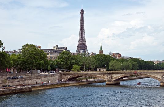 PARIS, FRANCE - JUNE 9, 2014: View of the Eiffel Tower with a bridge in the foreground.

Paris, France - June 9, 2014: View of the Eiffel Tower with a bridge in the foreground. People are walking by street.