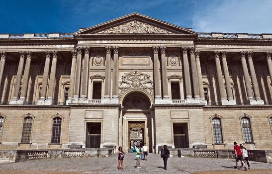 PARIS, FRANCE - JUNE 9, 2014: The Louvre Museum facade. Louvre is one of the biggest Museum in the world, receiving more than 8 million visitors each year.

Paris, France - June 9, 2014: The Louvre Museum facade. Louvre is one of the biggest Museum in the world, receiving more than 8 million visitors each year. People are walking near museum.