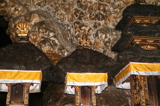 Altars at Pura Goa Lawah or Bat Cave Temple. Balinese Hindu temple in Pesinggahan, Klungkung, Bali, Indonesia. Many bats hanging from the ceiling of the Cave of bats. Colony of bats are waiting dark.