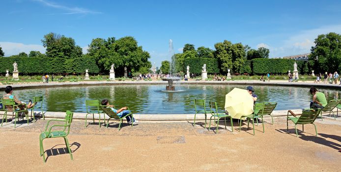 PARIS, FRANCE - JUNE 9: Tourist in famous Tuileries garden on June 9, 2014 in Paris, France. Tuileries Garden (Jardin des Tuileries) is a public garden located between the Louvre Museum and the Place de la Concorde.

Paris, France - June 9, 2014: Tourist in famous Tuileries garden. Tuileries Garden (Jardin des Tuileries) is a public garden located between the Louvre Museum and the Place de la Concorde. People are resting.