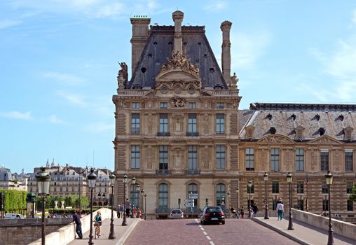 PARIS - JUNE 11: View of the Louvre from the bridge on June 11, 2014 in Paris, France. Louvre is one of the biggest Museum in the world, receiving more than 8 million visitors each year.

Paris, France - June 11, 2014: View of the Louvre from the bridge. Louvre is one of the biggest Museum in the world, receiving more than 8 million visitors each year. People are walking and looking at the sightseeings.