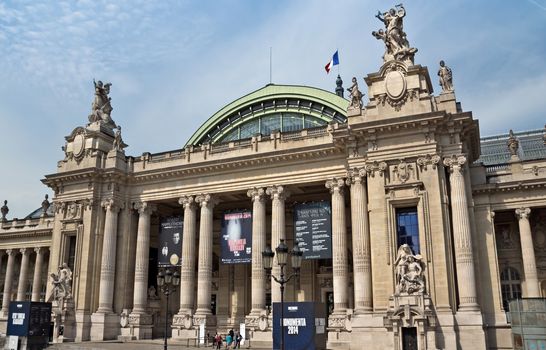 PARIS, FRANCE - JUNE 11, 2014: The Grand Palais. The Grand Palais shows art exhibitions and hosts different cultural events, attracting over 2 million people each year. 

Paris, France - June 11, 2014: The Grand Palais. The Grand Palais shows art exhibitions and hosts different cultural events, attracting over 2 million people each year. People are standing near museum.