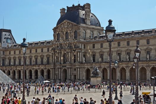 PARIS, FRANCE - JUNE 11, 2014: Louvre Museum. Louvre is one of the biggest Museum in the world, receiving more than 8 million visitors each year.

Paris, France - June 11, 2014: Louvre Museum. Louvre is one of the biggest Museum in the world, receiving more than 8 million visitors each year. People are walking by square.