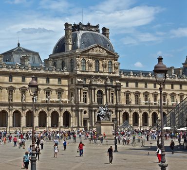PARIS, FRANCE - JUNE 11, 2014: Louvre Museum. Louvre is one of the biggest Museum in the world, receiving more than 8 million visitors each year.

Paris, France - June 11, 2014: Louvre Museum. Louvre is one of the biggest Museum in the world, receiving more than 8 million visitors each year. People are walking by square.