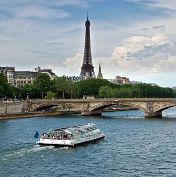 PARIS, FRANCE - JUNE 9, 2014: View of the Eiffel Tower with a bridge in the foreground.

Paris, France - June 9, 2014: View of the Eiffel Tower with a bridge in the foreground. People are travelling by boat.